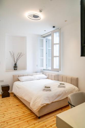 a bedroom with a large white bed with a window at Epos by the Sea in Larnaca