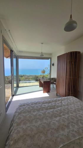 a bedroom with a bed and a view of the ocean at Tendu' Punta Bianca Glamping Camp in Palma di Montechiaro