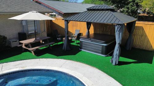 a gazebo and a grill next to a pool at Holiday 4BR 2BA Home with Pool, Hot Tub, Fire Pit in Irving