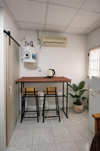 a kitchen with a table and two stools at Hospedaje Don Felix in General Acha