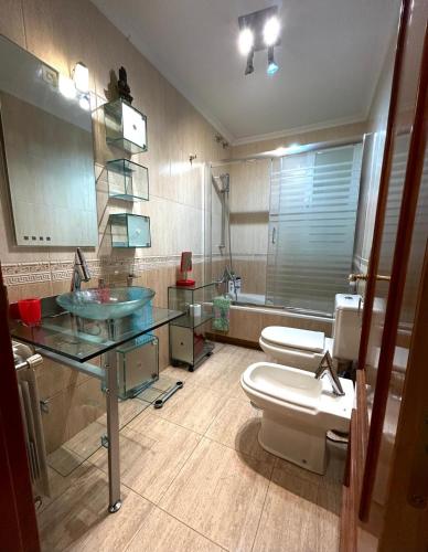 a bathroom with a sink and a toilet and a mirror at Buenos Aires apartamento in Guadix