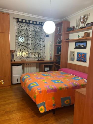 a bedroom with a bed with a colorful blanket at Buenos Aires apartamento in Guadix