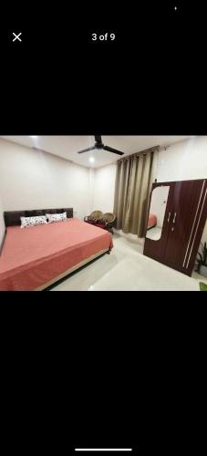 a bedroom with a bed with a red bedspread at Pink villa inn in Guwahati