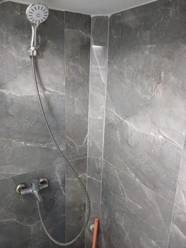 a shower with a shower head on a wall at Mavi Apart in Demre