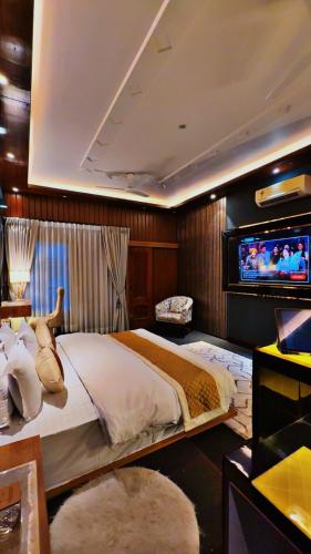 a bedroom with a large bed and a tv at Victorian Elegance Luxury Stays in Amritsar