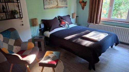 a bedroom with a bed and a chair at "En Aqualye" Appartement 2 personnes chez l'habitant in Aywaille