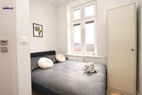 a bedroom with a bed with pillows on it at MMRent Grape Room in Gdańsk