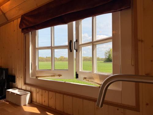 a window in a room with a view of a field at CRASH'NSTAY - Moppie Avenue in Hooge Vaart