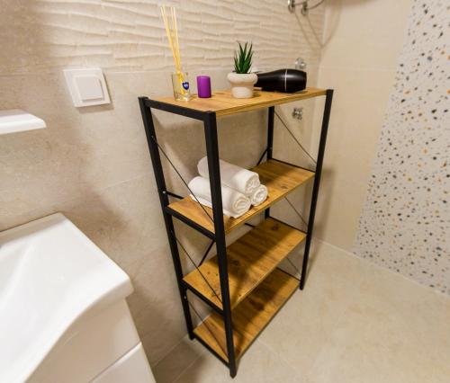 a bathroom with a shelf with towels and a shower at Bay Horizon View in Igalo