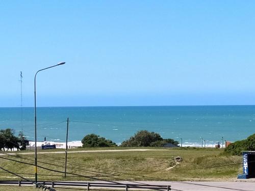 a street light on the side of a road near the ocean at Luz de faro in Mar del Plata