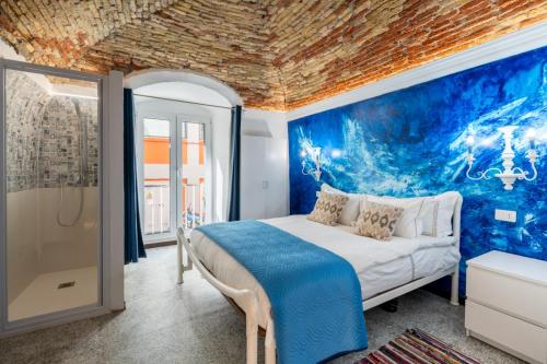 ein Schlafzimmer mit einem Bett und einer blauen Wand in der Unterkunft Ellie in Imperia