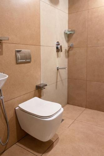 a bathroom with a shower with a toilet and a sink at Maleyam Homestay in Kozhikode