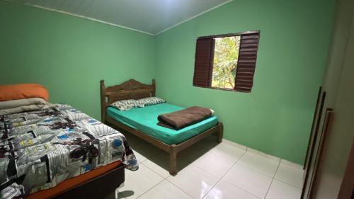 a small bedroom with a bed and a window at Aconchego ao pé da serra in São Roque de Minas