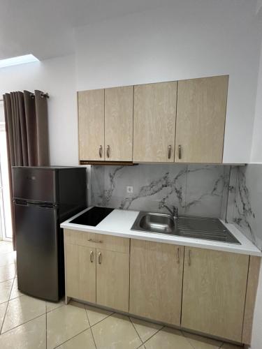 a kitchen with a sink and a refrigerator at Ksamil Apartament Sela in Ksamil
