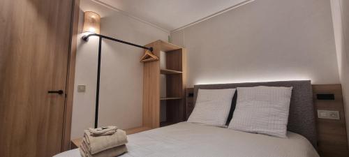 a bedroom with a bed with white sheets and a lamp at Gîte isolé avec terrasse in Laignes