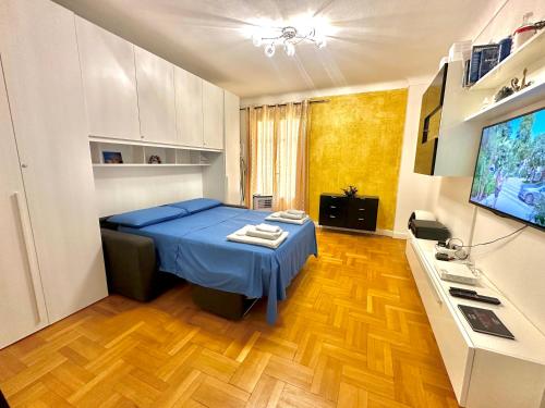 a bedroom with a blue bed and a television at Monaco Home just 200 mt from Casinò Monte Carlo in Monte Carlo