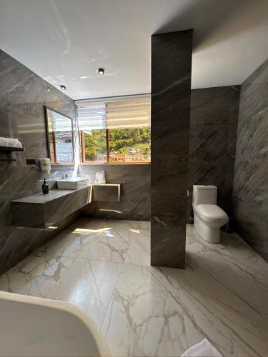 a bathroom with a tub and a sink and a toilet at Hotel Casa Agave in Baños