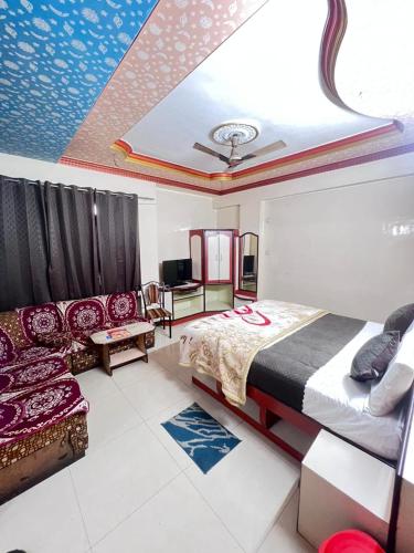 a bedroom with a bed and a couch in it at Shree Sanwariya Hotel in Chittaurgarh