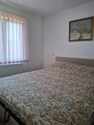a bed in a bedroom with a blanket on it at Vikendica Popadić in Vukovina