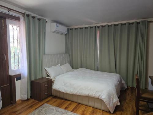 a bedroom with a white bed and a window at Fu Shang Villa in Kathmandu