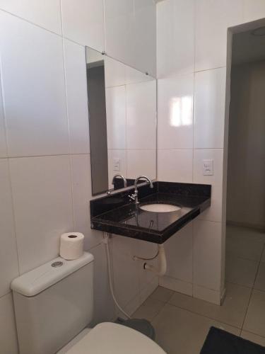 a bathroom with a sink and a toilet and a mirror at Casa charmosa, e bem localizada in Juazeiro do Norte