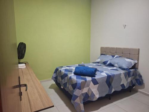 a bedroom with a bed with blue pillows on it at Casa charmosa, e bem localizada in Juazeiro do Norte