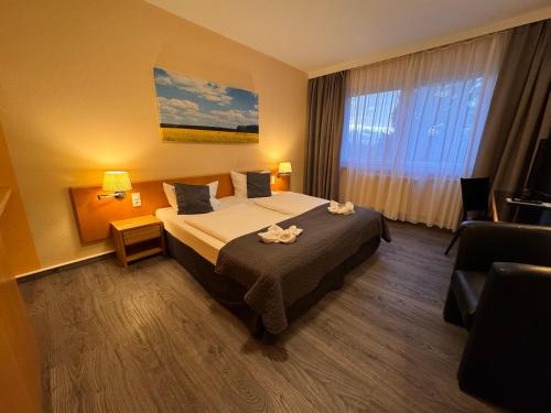 a hotel room with a bed and a window at Hotel am Tierpark in Güstrow