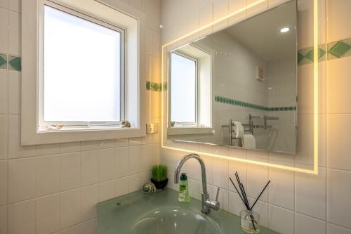 a bathroom with a sink and a mirror at Premium Seaview Villa in Waiheke Island