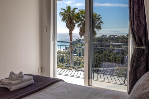 a bedroom with a bed and a large sliding glass door at Premium Seaview Villa in Waiheke Island