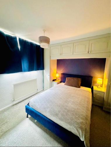 a bedroom with a large bed and two lamps at Unnati stay in Buckinghamshire