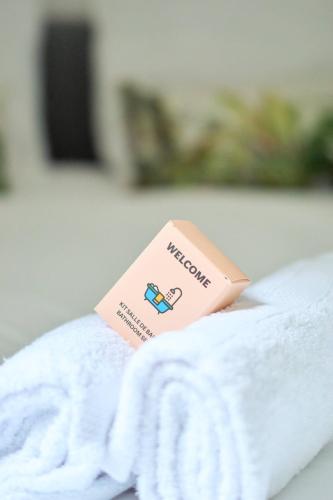 a pink tag on top of a white towel at Apparthotel Beauregard 12 cœur de Nantes WIFI in Nantes
