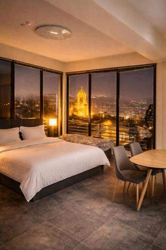 a bedroom with a bed and a view of a city at Natali Apart-hotel in Tbilisi City
