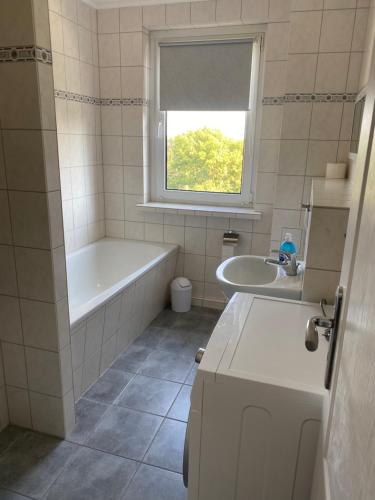 a white bathroom with a tub and a sink at Ferienwohnung in Ostseenähe 1 in Velgast