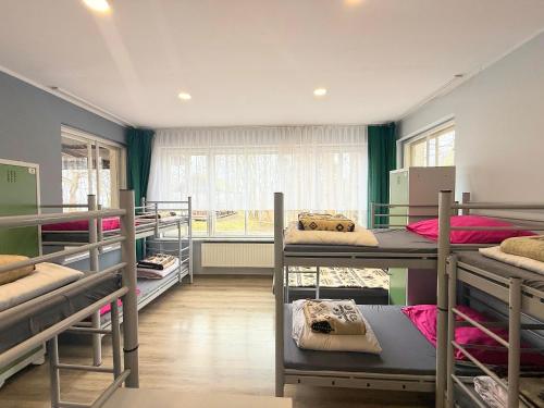 a room with several bunk beds and a window at BP Hostel Gdynia in Gdynia