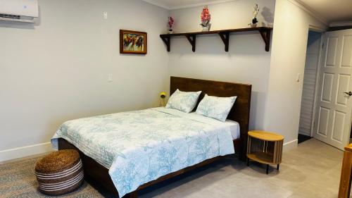 a bedroom with a bed with a blue comforter at Ensuite Condo Aruba in Palm-Eagle Beach