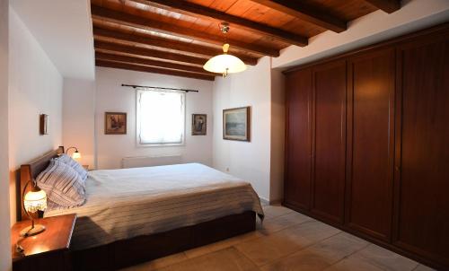 a bedroom with a large bed and a window at Tinos Sky View Villa in Arnados
