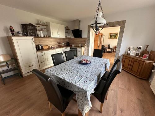 a dining room with a table with chairs and a kitchen at Ferienwohnung am Warnowhang in Kessin