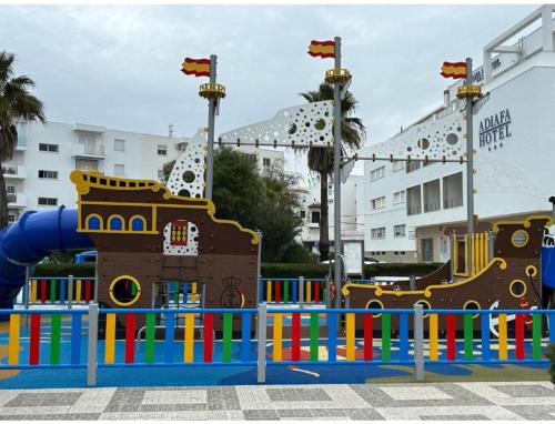 a playground in front of a large building at La Casa del Mar in Barbate