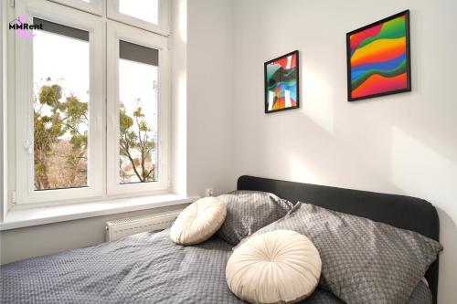 a bedroom with a bed and two windows at MMRent Colorful Room in Gdańsk