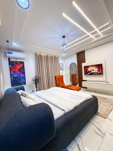 a bedroom with a large bed and a couch at Abuja Lux Apartment Wuye in Abuja