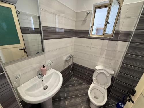 a bathroom with a sink and a toilet at Grand Seaview Apartments in Ksamil