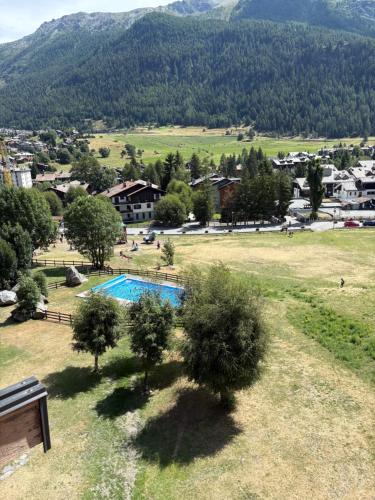 a resort with a swimming pool in a field at Casa Raggio di Sole in La Thuile