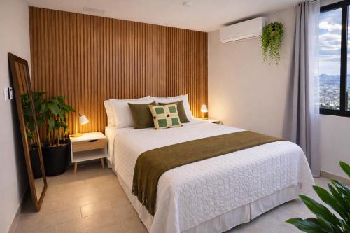 a bedroom with a large bed and a window at Apartamento con vistas, balcón, gym y parking in Tegucigalpa