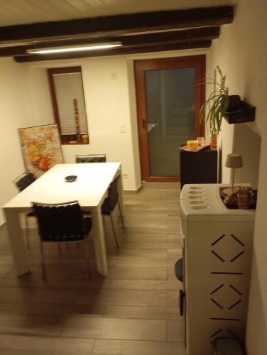 a kitchen with a white table and a table and a counter at Casa Willo in Bellinzona