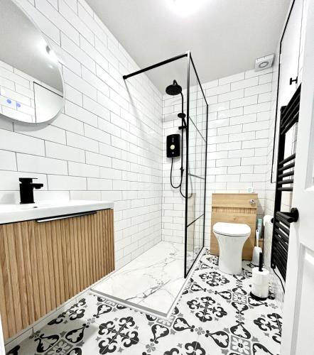 a bathroom with a shower and a toilet and a sink at Cosy Coastal Cottage in Tynemouth