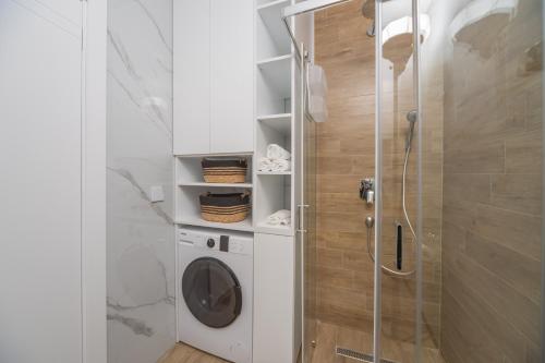 a bathroom with a washing machine and a shower at Rajjan in Bar