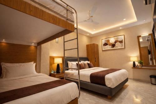 a bedroom with two beds and a bunk bed at Travinities Premier, Ujjain in Ujjain