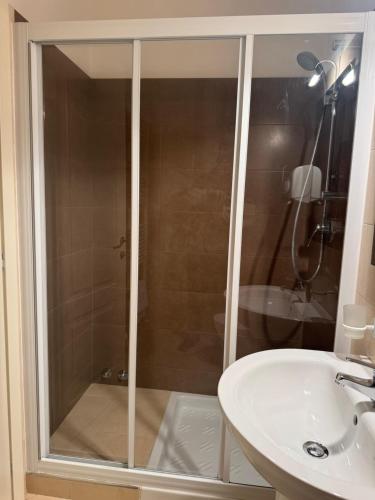 a shower with a glass door next to a sink at Villa Flavia in Arezzo