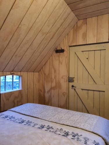 a bedroom with a bed with a barn door at Woonwagen Carpe Diem in Oudwoude