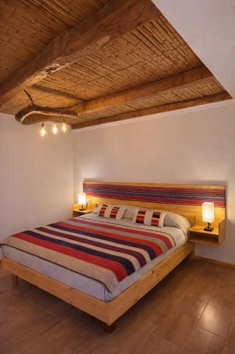 a bedroom with a large bed with two lamps at Puna Hostel in San Pedro de Atacama